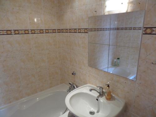 uma casa de banho com um lavatório, uma banheira e um espelho. em Apartmán Trutnov em Trutnov
