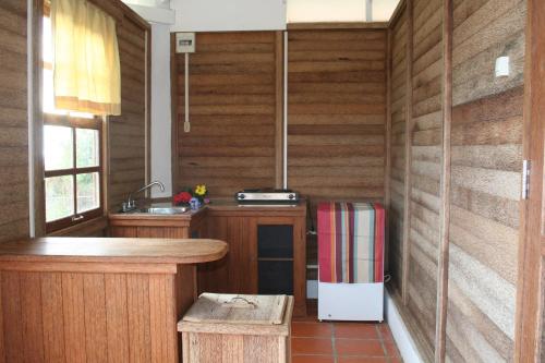 a kitchen with wooden walls and a counter and a refrigerator at Statia Lodge in Oranjestad