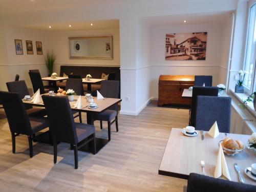 a restaurant with tables and chairs and a piano at Hotel Sonnenklause in Travemünde