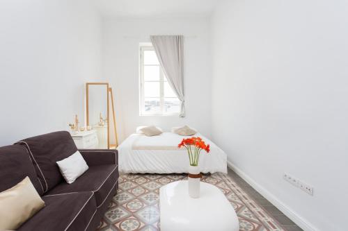 sala de estar con sofá y cama en Palacio de Daoiz lofts, en Santa Cruz de Tenerife