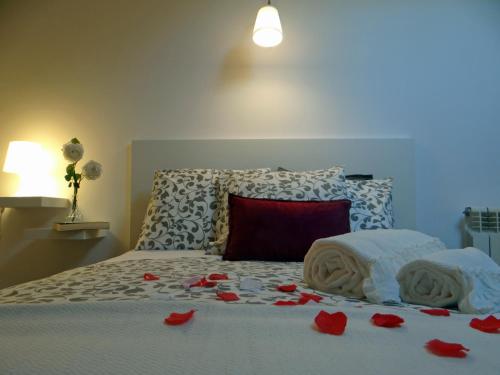 a bedroom with a bed with red rose petals on it at S. João Porto Apartment in Porto