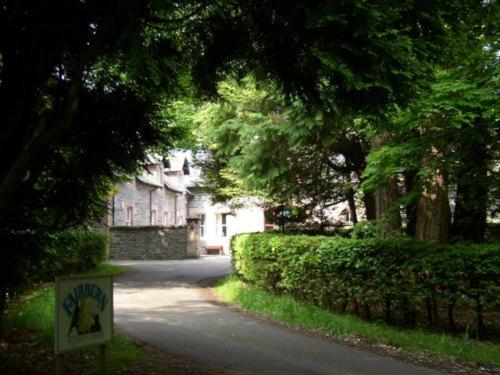 a street with a house and trees and a sign at Fairburn Activity Centre in Contin