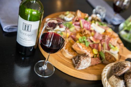 a bottle of wine and a plate of food and a wine glass at Strandhotel Bos en Duin in Oostkapelle