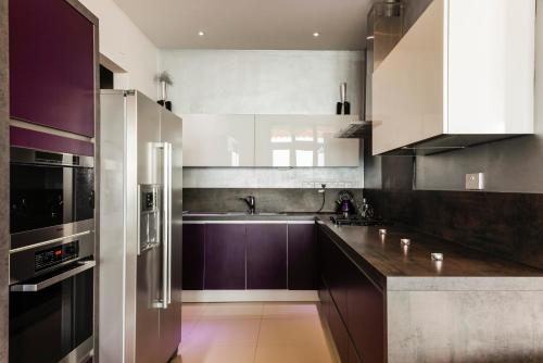 a kitchen with stainless steel appliances and purple cabinets at Beach Villa Pantheon in Pomos