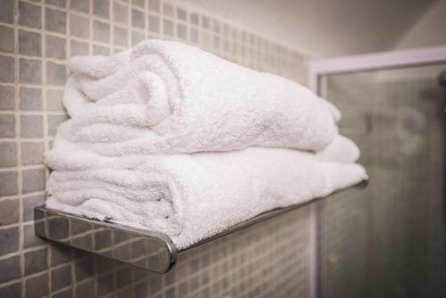 een stapel handdoeken op een plank in een badkamer bij Sailors Rest Riomaggiore - Cinque Terre in Riomaggiore