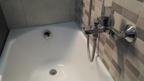 y baño con bañera y grifo. en Érsek Apartman Eger, en Eger