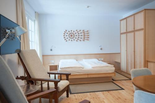 a bedroom with a bed and a chair at Parkhotel Sole Paradiso in San Candido