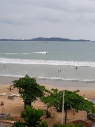 a beach with people swimming in the water at Seals Harbor Hotel in Weligama