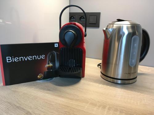 un frullatore rosso e un bollitore per il tè su un tavolo di All In One a Bruxelles