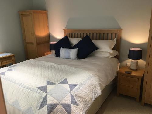 1 dormitorio con 1 cama con edredón azul y blanco en The Old Stables, en Hinton Charterhouse