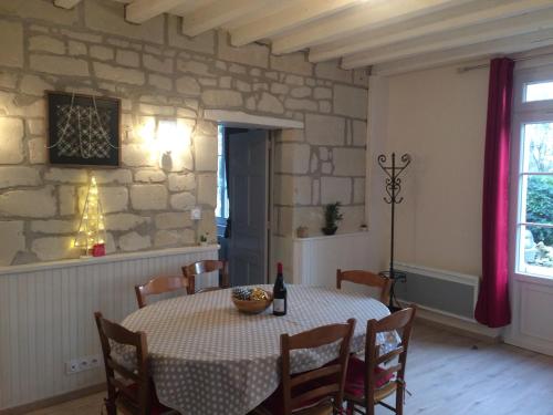 une salle à manger avec une table et un mur en pierre dans l'établissement Domaine des Aubuis, à Chinon