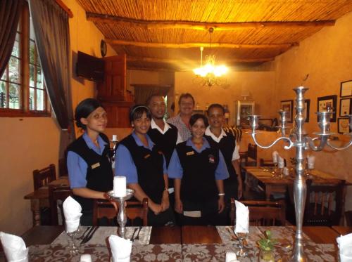 a group of people posing for a picture in a restaurant at Old Mill Lodge, Seasonal Working Ostrich Farm & Restaurant, Oudtshoorn in Oudtshoorn