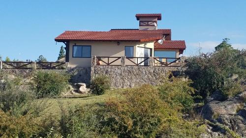 a house on the side of a hill at Aires Serranos - Suites in La Cumbrecita