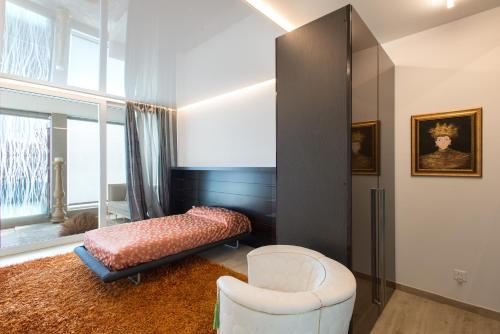 ルガノにあるDL Boutique Apartmentsのベッドルーム1室(ベッド1台、椅子、窓付)