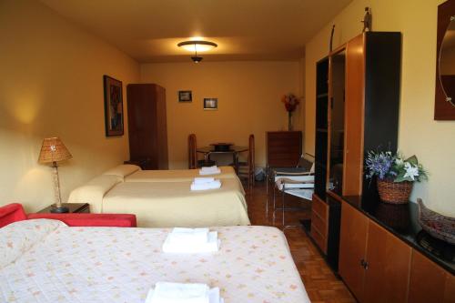 a hotel room with two beds and a couch at Pensión Acella in Pamplona