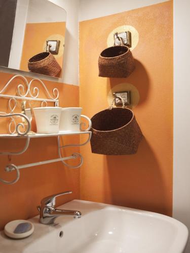 a bathroom with baskets on the wall and a sink at B&B Contrada Lunga in Abbadia Lariana