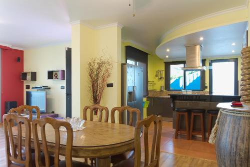 a kitchen and dining room with a table and chairs at Casa do Serrado in Ponta do Sol