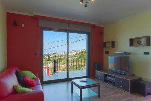 a living room with a couch and a television at Casa do Serrado in Ponta do Sol