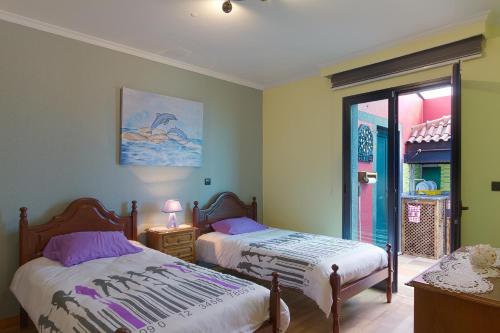 a bedroom with two beds and a window at Casa do Serrado in Ponta do Sol