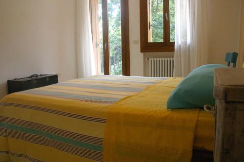 a bedroom with a bed with a yellow blanket at Antica Corte Leguzzano B&B in San Vito di Leguzzano