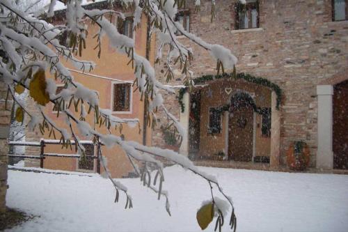 a tree covered in snow in front of a building at Antica Corte Leguzzano B&B in San Vito di Leguzzano