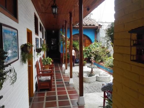 a courtyard of a building with chairs and plants at Hotel Alcarraza in Calima