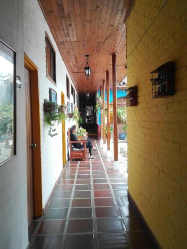 a person sitting in a chair in an alley way at Hotel Alcarraza in Calima