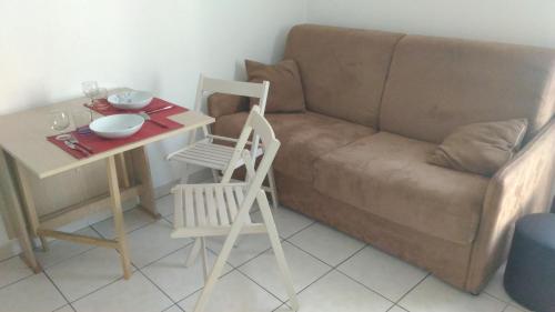 un salon avec un canapé, une table et une chaise dans l'établissement Californie Appartement, à Nice