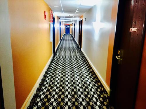 a long hallway with a black and white tiled floor at Lyons Inn in Lyons