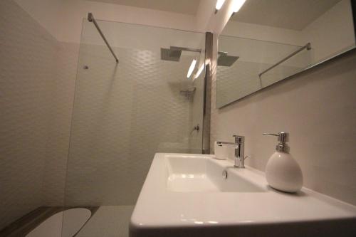 a white bathroom with a sink and a mirror at Principe in Bari