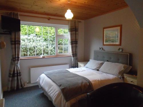 1 dormitorio con cama y ventana grande en Hillside Haven, en Tahilla