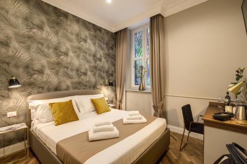 a bedroom with a bed with yellow pillows at Charme Spagna Boutique Hotel in Rome