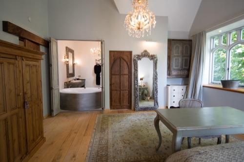 a bathroom with a tub and a table and a mirror at The French Country House, Tauranga in Omokoroa Beach