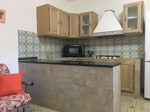 a kitchen with a microwave and a stove top oven at Appartamenti Cala Azzurra in Scopello