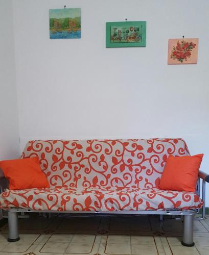 a couch with two red pillows sitting in a room at Appartamenti Cala Azzurra in Scopello
