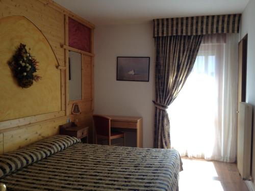een hotelkamer met een bed en een raam bij Hotel Dal Bon in Andalo