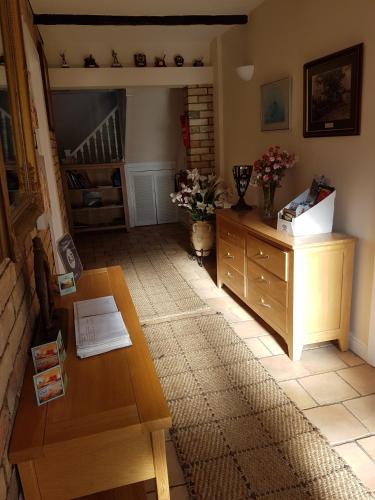 a living room with a coffee table and a stairway at The Brambles B&B in Waterbeach