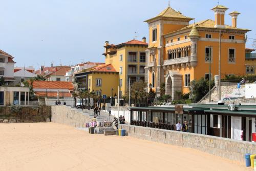 a group of buildings with people walking on a sidewalk at Ocean Center Apartments in Cascais