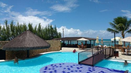 a large swimming pool with a resort with a beach at Muro Alto Marupiara Flats in Porto De Galinhas