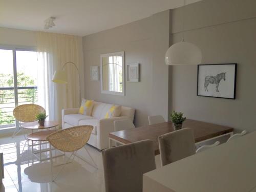ein Wohnzimmer mit Sofa, Tisch und Stühlen in der Unterkunft Edificio Celedonio Gutiérrez 651 in San Miguel de Tucumán