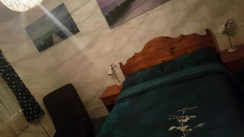 a bedroom with a bed with a wooden head board at Chelford Guesthouse in Marthall