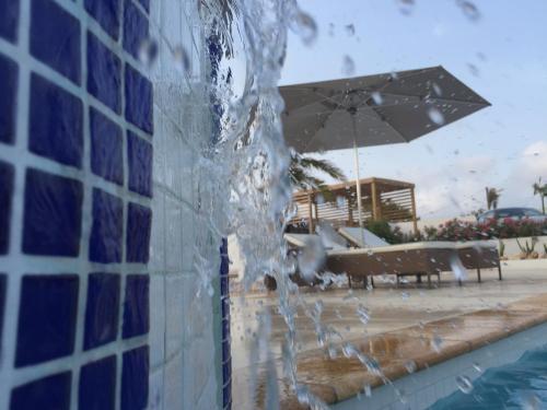 a pool with water pouring out of a building at Malika Apartments in Westpunt