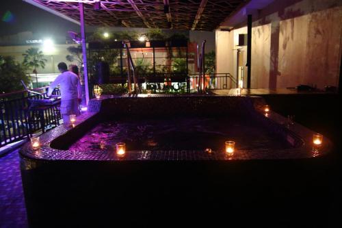 a person standing on a patio at night with lights at Metland Hotel Bekasi in Bekasi