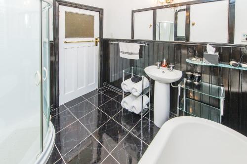La salle de bains est pourvue d'un lavabo et d'un ours en peluche assis dans une chaise. dans l'établissement Gumnut House., à Whanganui