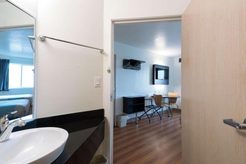 a bathroom with a sink and a mirror and a bedroom at Motel 6-Pottstown, PA in Pottstown