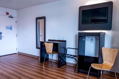 a room with a desk and a tv and chairs at Motel 6-Pottstown, PA in Pottstown