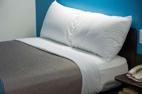 a white pillow sitting on top of a bed at Motel 6-Pottstown, PA in Pottstown