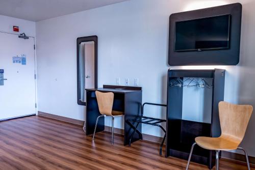 a room with a desk and a tv and chairs at Motel 6-Pottstown, PA in Pottstown
