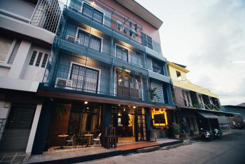 a building with a bunch of windows on it at Chernchan Hostel in Chanthaburi