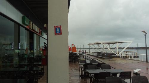a restaurant with tables and chairs next to the water at Mangue Oranje Hostel - no bairro do Recife Antigo - Old Town in Recife
